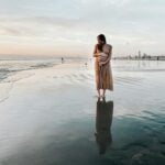 pregnancy: woman in brown dress standing on beach during daytime