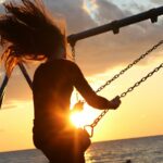 woman riding on swing during sunset capturing life aesthetics